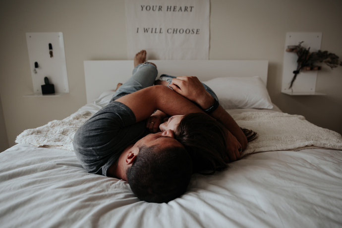 Couple cuddling closely in bed