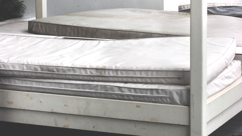 Old thin mattresses piled on top of each other to be thrown away