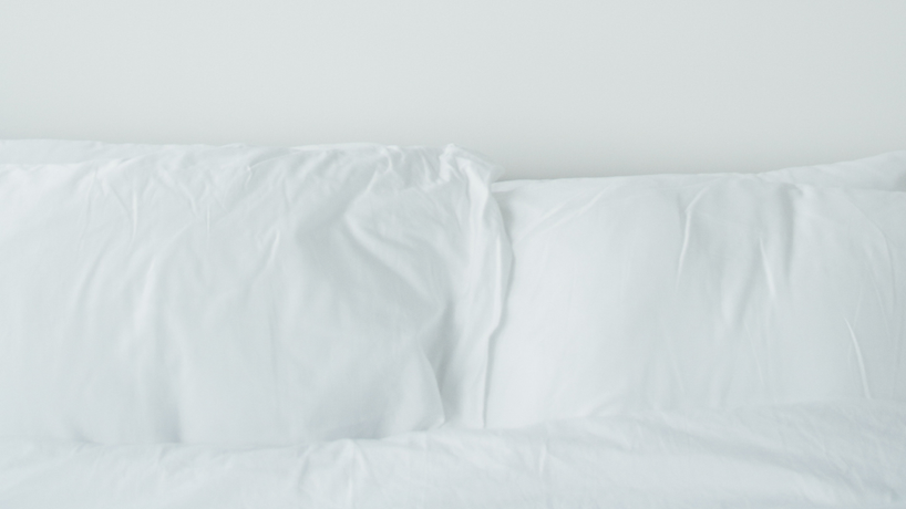 Picture of two pillows in white pillowcases propped up side by side next to each other