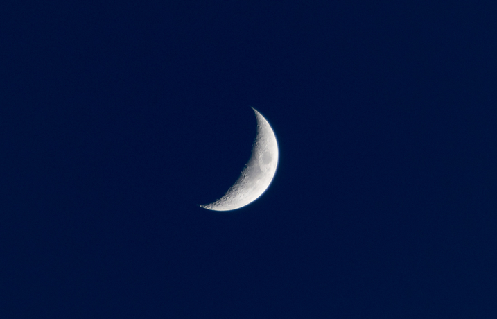 Crescent moon against a dark blue sky