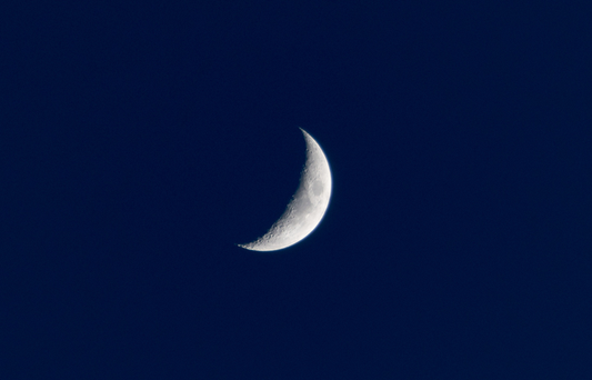 Crescent moon against a dark blue sky
