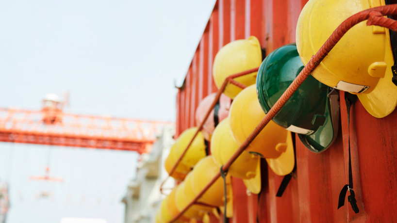 Hard hats put up on the side of an orange construction container