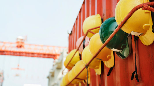 Hard hats put up on the side of an orange construction container