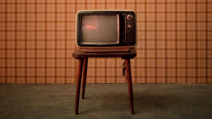 Small retro TV on top of a vintage small table