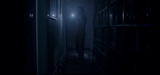 Picture of someone walking in the dark with a flashlight