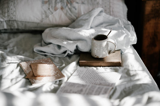 Bed with a book and cup of coffee sitting on top of it