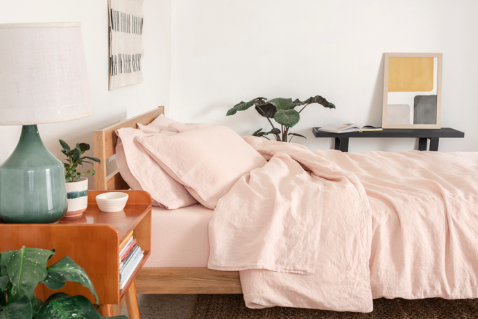 Side view of a bed made with pink Tuft & Needle bedding