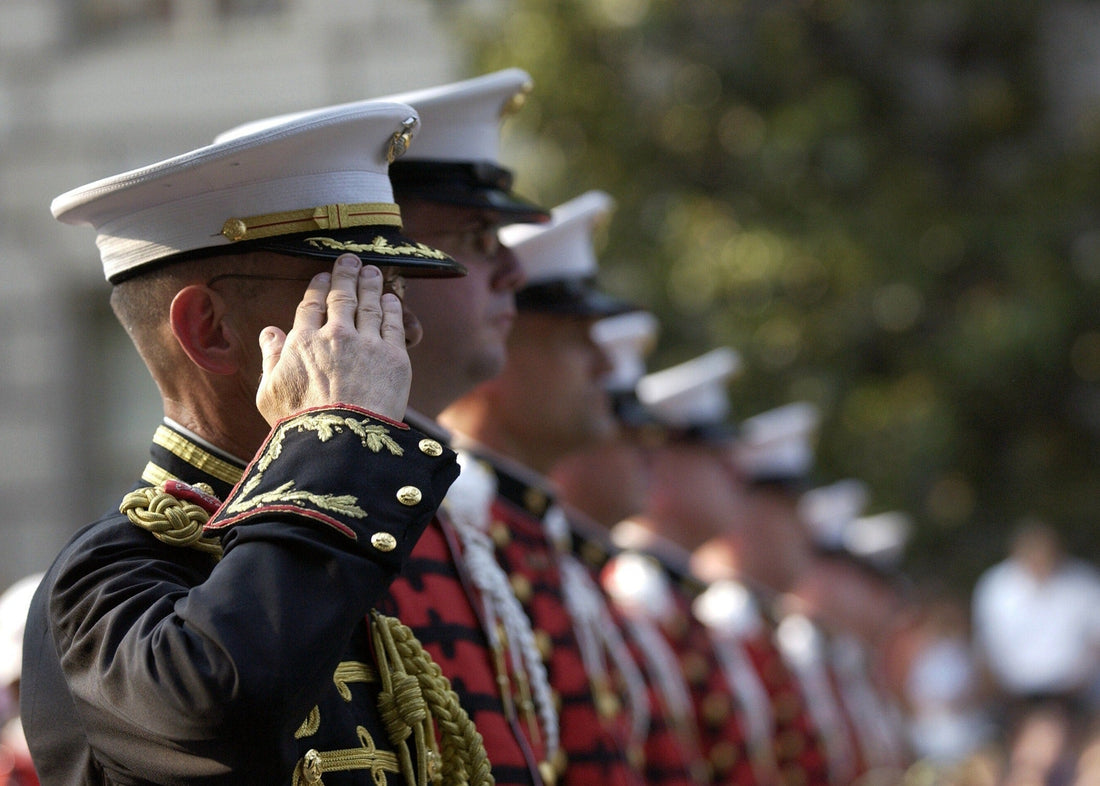Picture of the side profile of men in uniform and one of them saluting