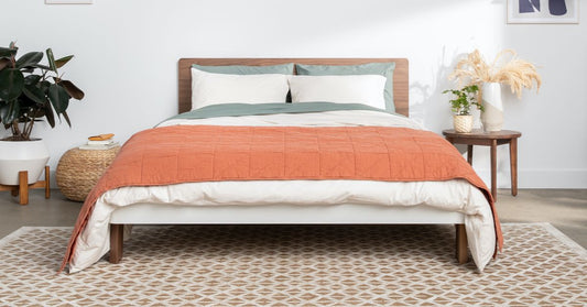 Bed with orange bedding depicted in a room.