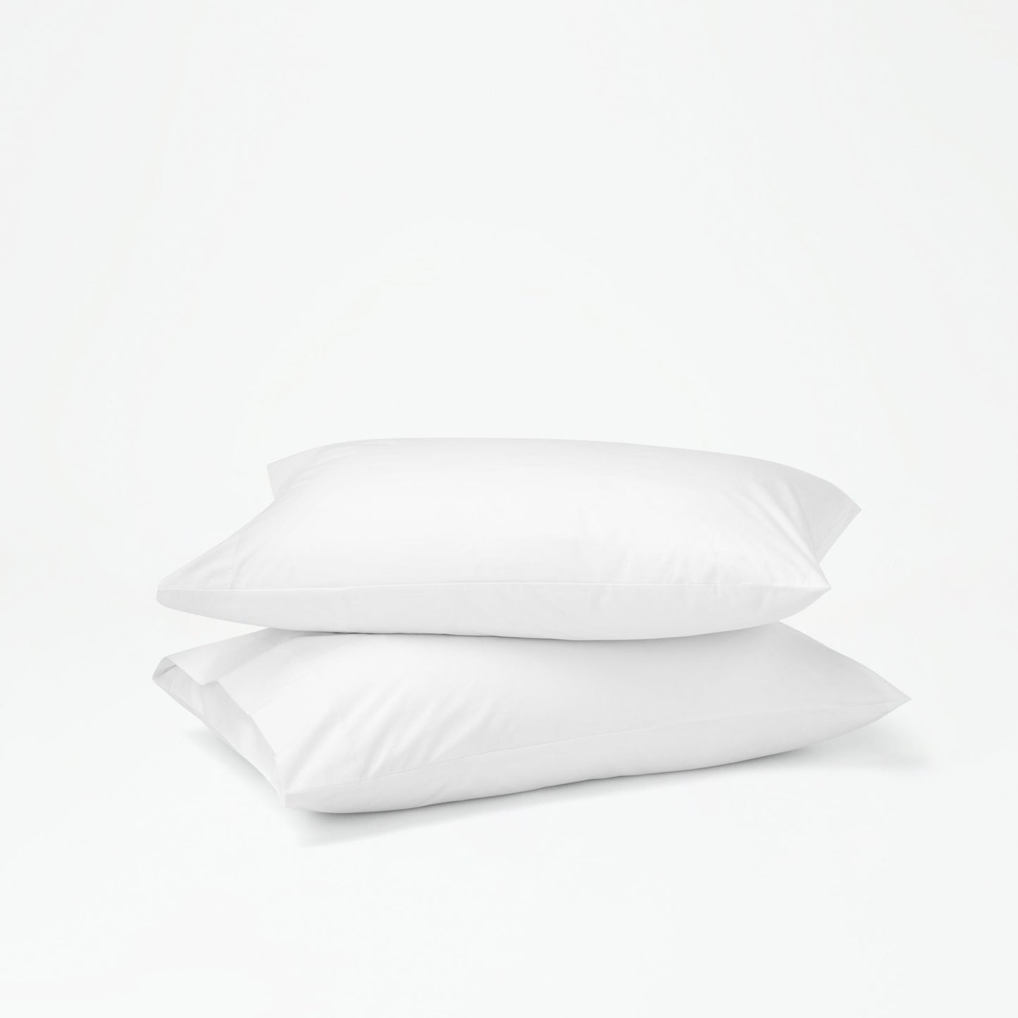 The Tuft and Needle Percale Pillowcase Set on two stacked pillows||color:cloud