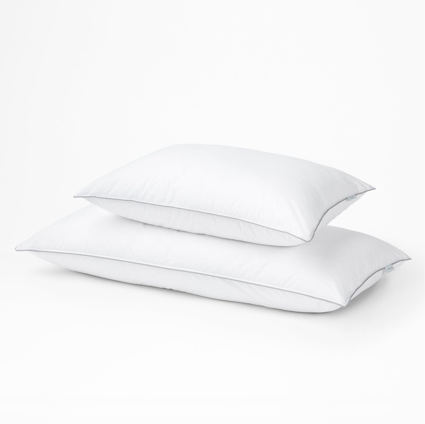 Two tuft and needle down alternative pillows, standard on top and large on the bottom