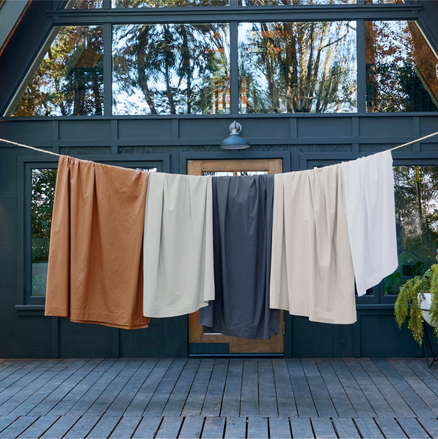 Different colored percale sheets hanging on a clothes line.