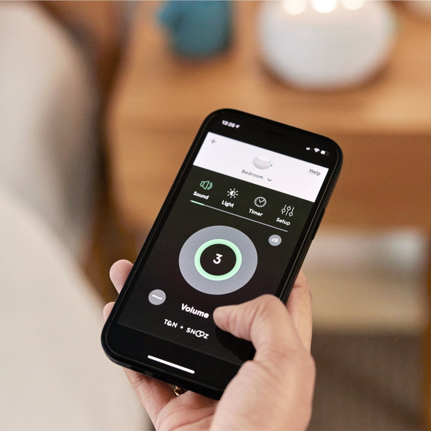 Hand holding a remote for the white noise machine