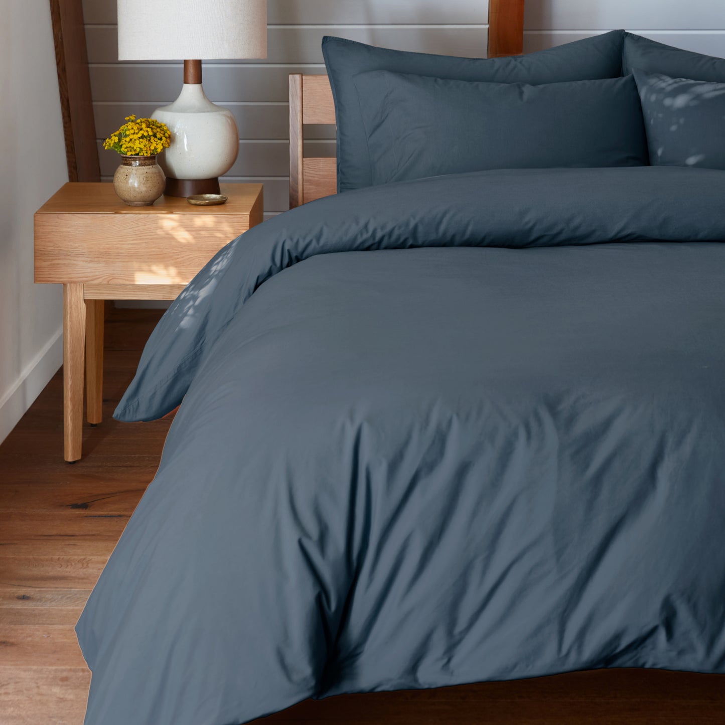 The Tuft and Needle Percale Duvet Cover Set on a mattress in a bedroom ||color:slate