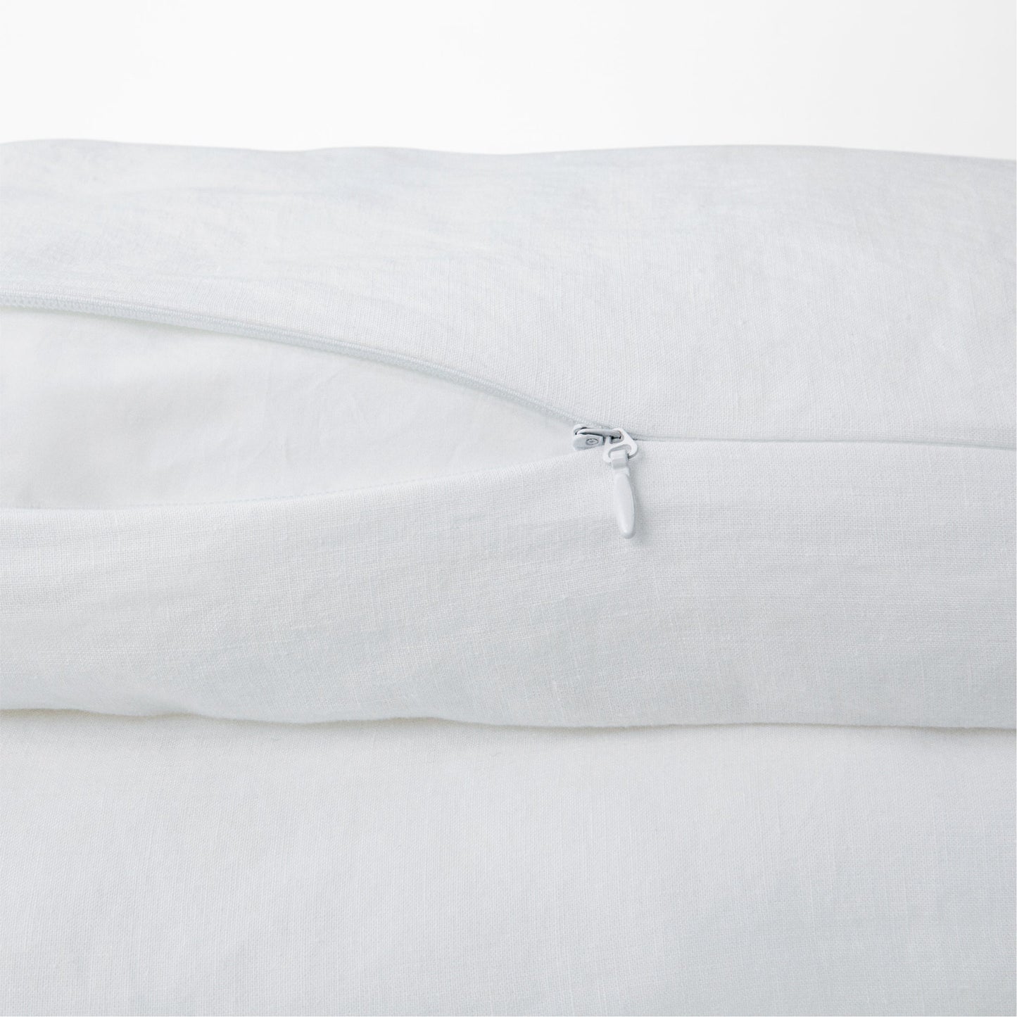 Close-up of a white pillow with a zipper on a white background