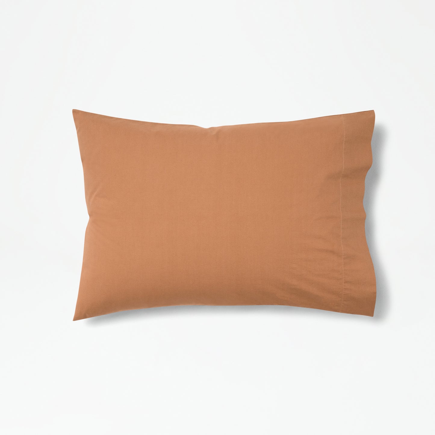 The Tuft and Needle Percale Pillowcase Set on one pillow||color:canyon