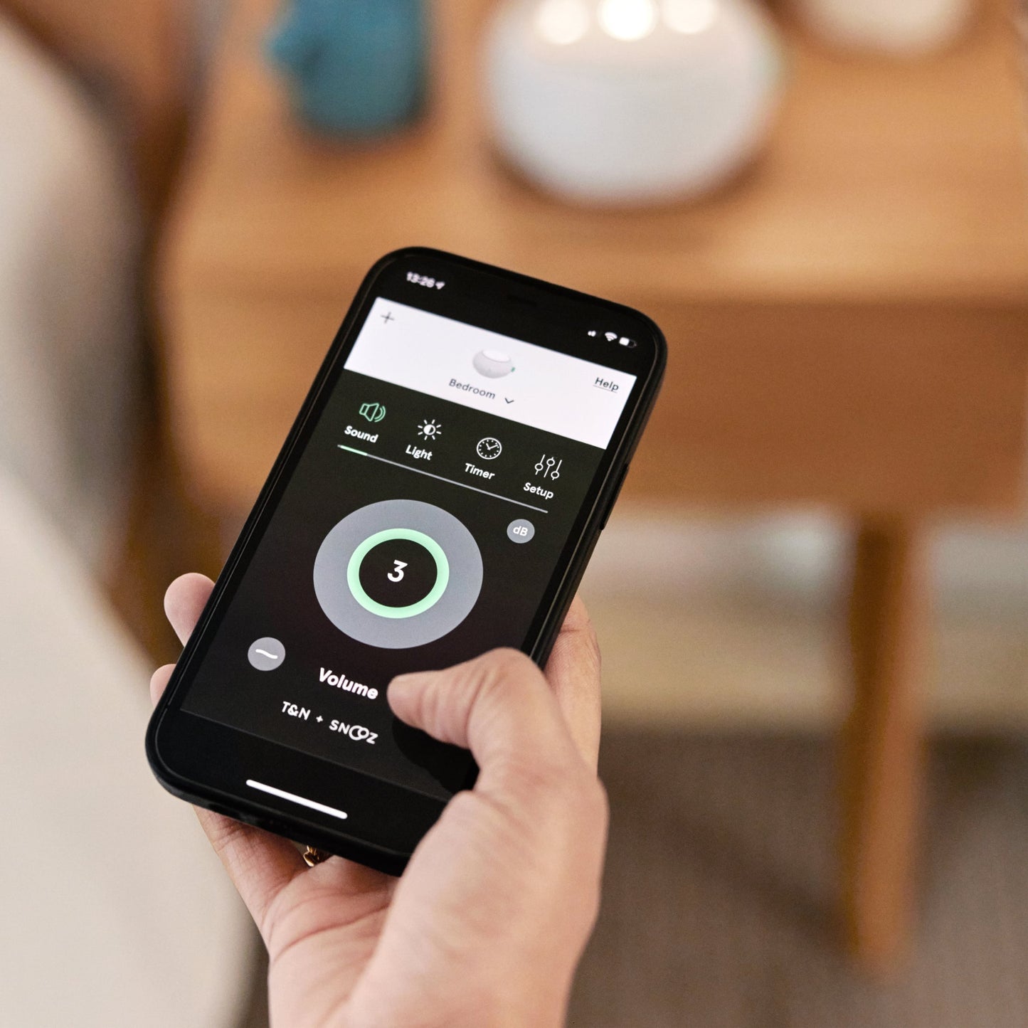 A person using the Tuft and Needle White Noise Machine app on their phone