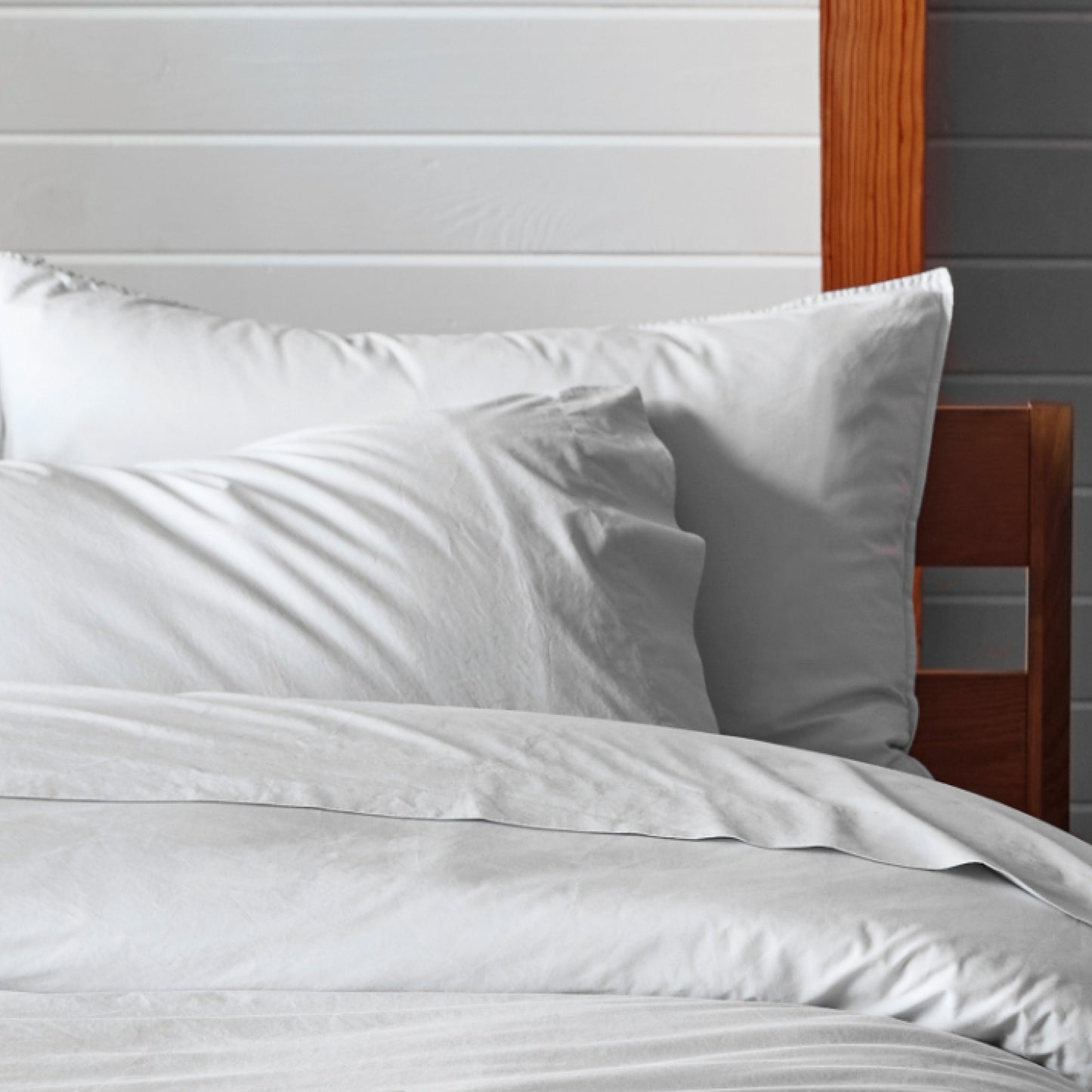 The Tuft and Needle Percale Pillowcase Set on a mattress in a bedroom||color:sand