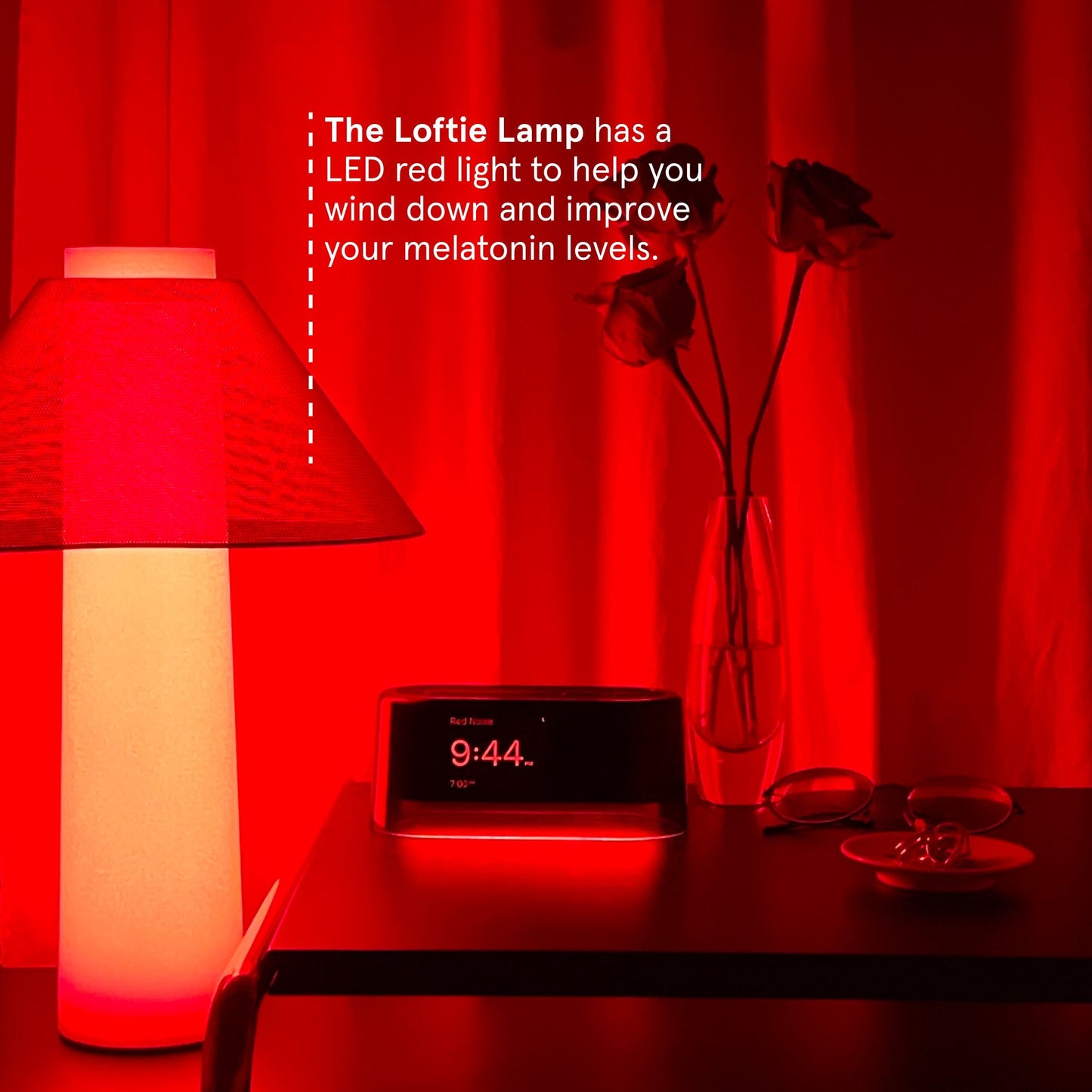 The Loftie Lamp sitting on a table beside the Loftie Smart Alarm Clock with the caption stating: The Loftie Lamp has a LED red light to help your wind down and improve your melatonin levels