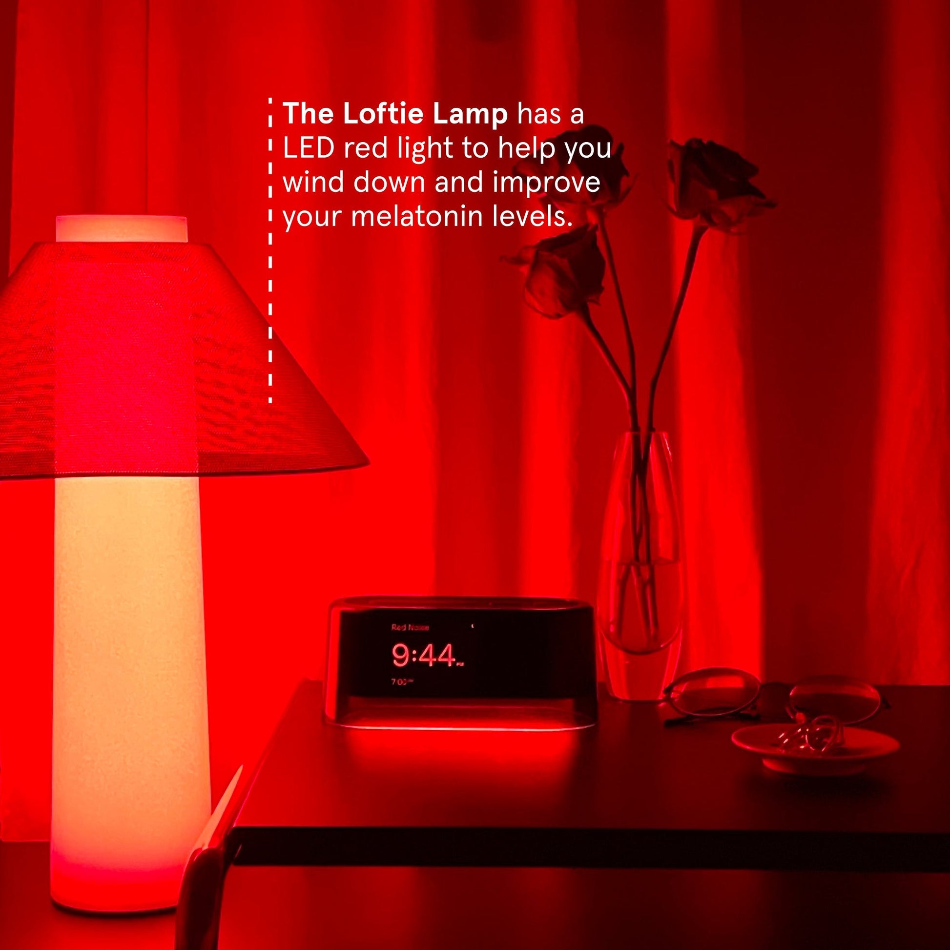 The Loftie Lamp sitting on a table beside the Loftie Smart Alarm Clock with the caption stating: The Loftie Lamp has a LED red light to help your wind down and improve your melatonin levels