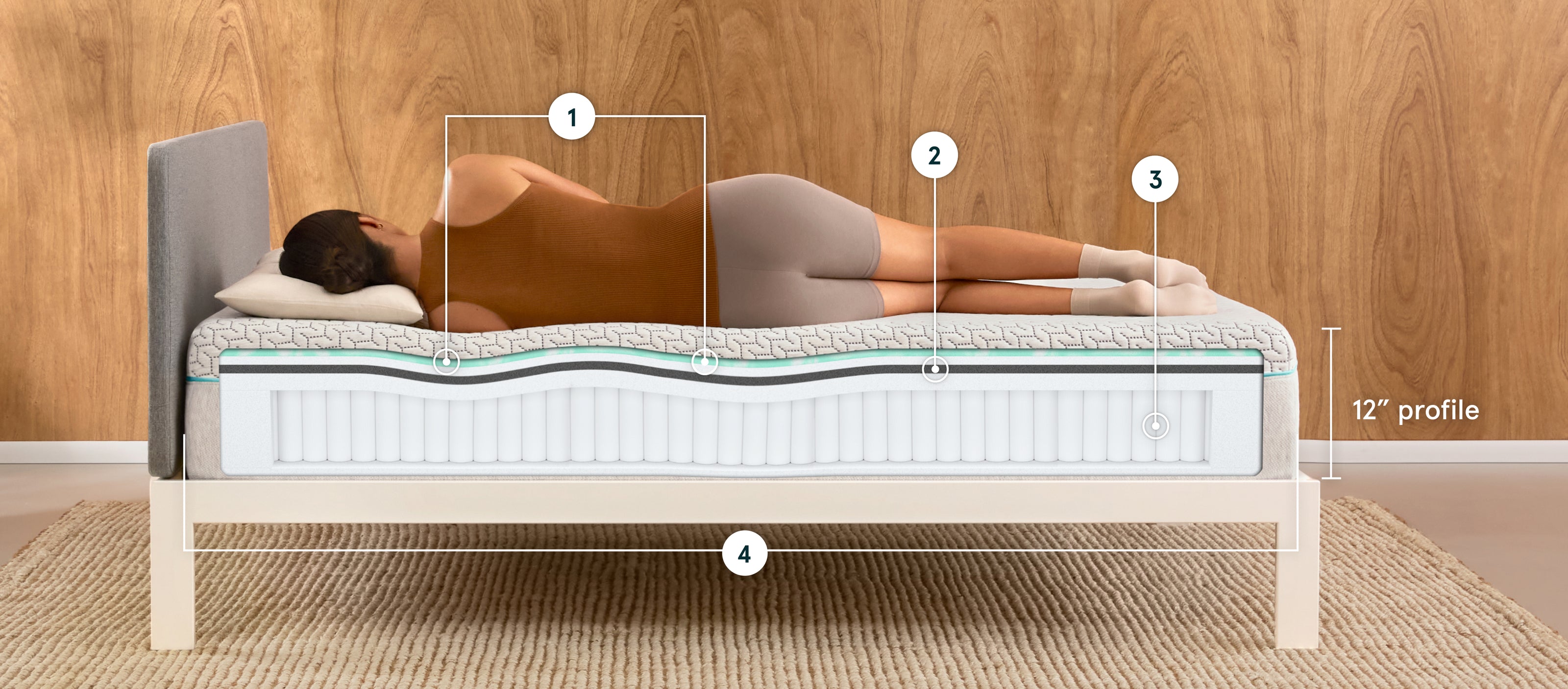 Person lying on their side on a 12" profile Tuft & Needle mattress with layers showing, on a bed frame.