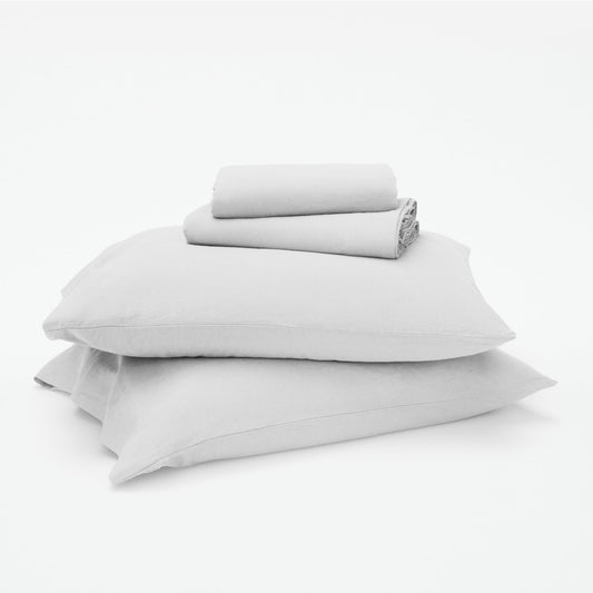 The Tuft and Needle Linen-Cotton Blend Sheet Set, 2 sheets stacked on 2 pillows || color: Cloud