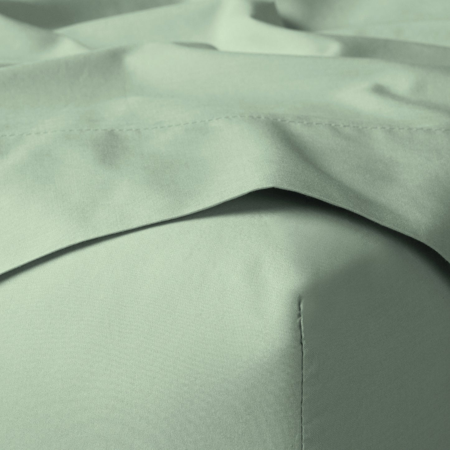 The Tuft and Needle Classic Percale Sheet Set, corner of a mattress with both sheets showing || color: Sage
