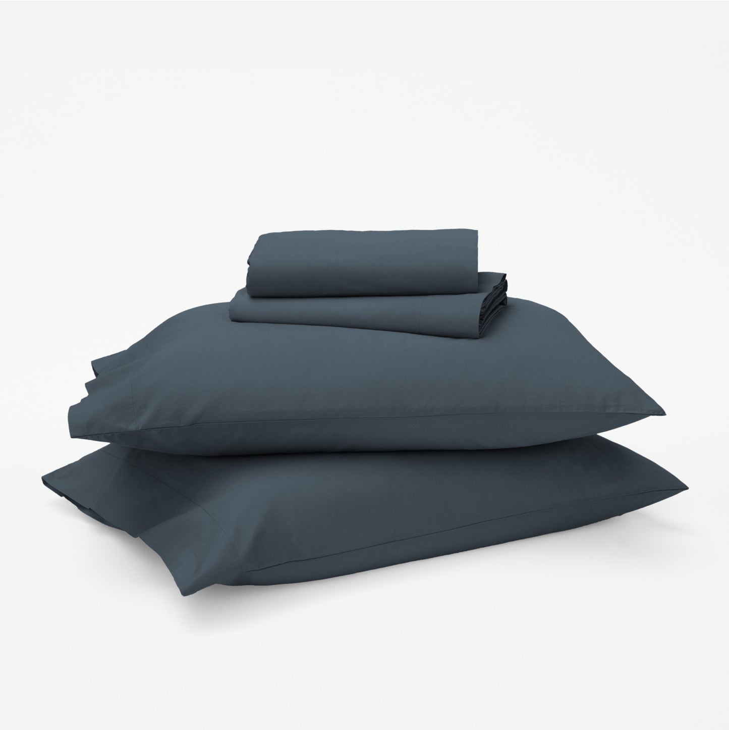 The Tuft and Needle Classic Percale Sheet Set, 1 sheet and pillowcases stacked on top of 2 pillows || color: Slate