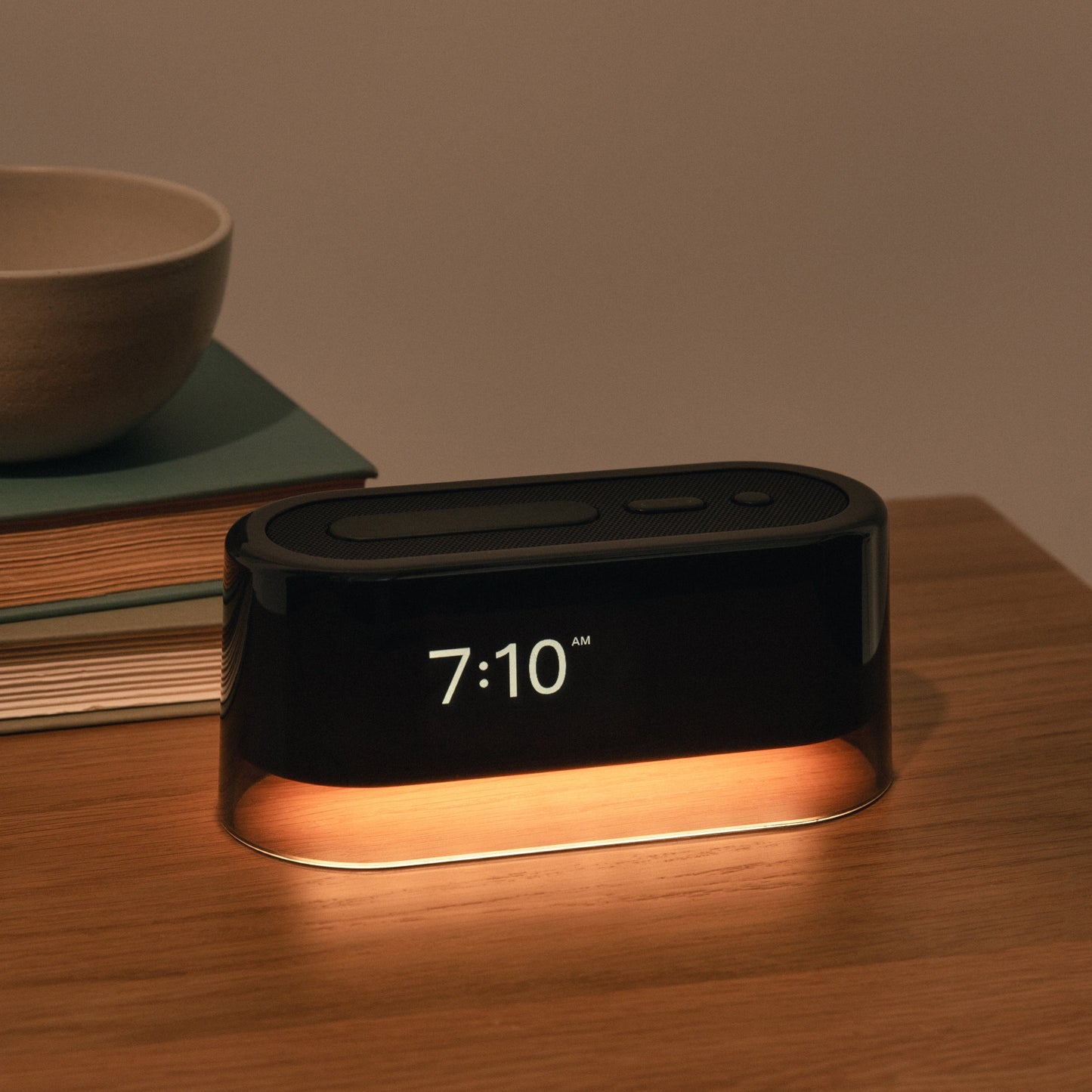 The Tuft and Needle Loftie Smart Alarm Clock on a nightstand in a bedroom