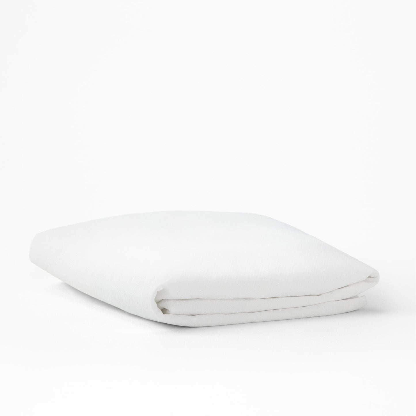 The Tuft and Needle Mattress Protector folded on a white background