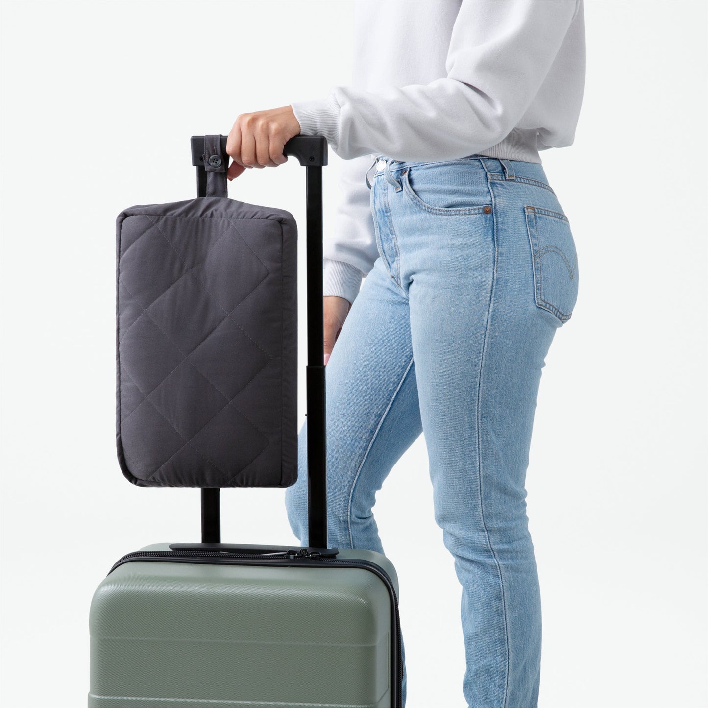 The Anywhere Travel Blanket strapped to a womans suitcase handle