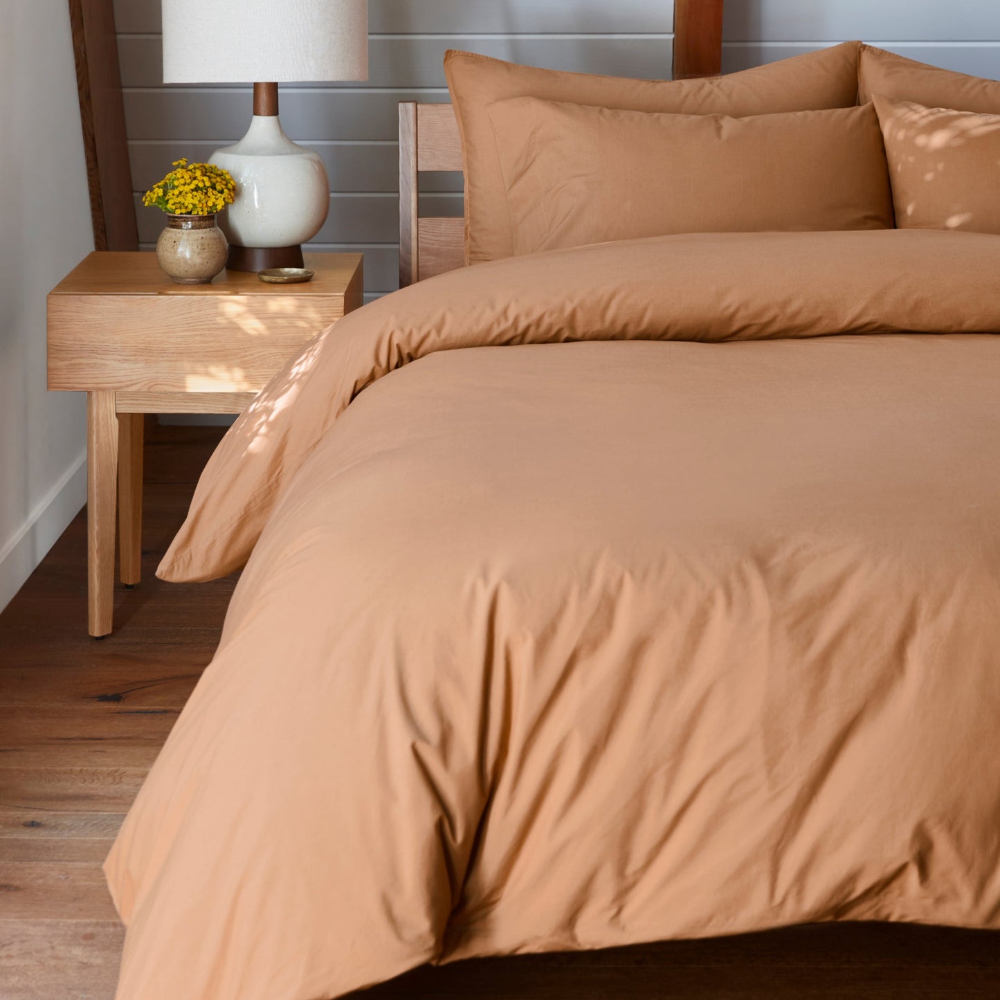 The Tuft and Needle Percale Duvet Cover Set on a mattress in a bedroom||color:canyon