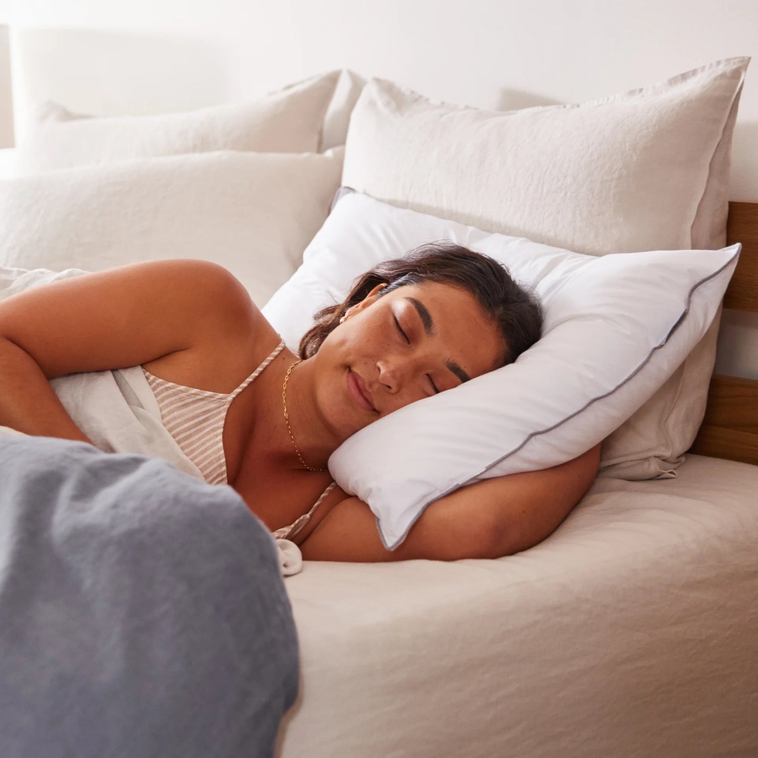 Woman is asleep in a bed using T&N bedding.