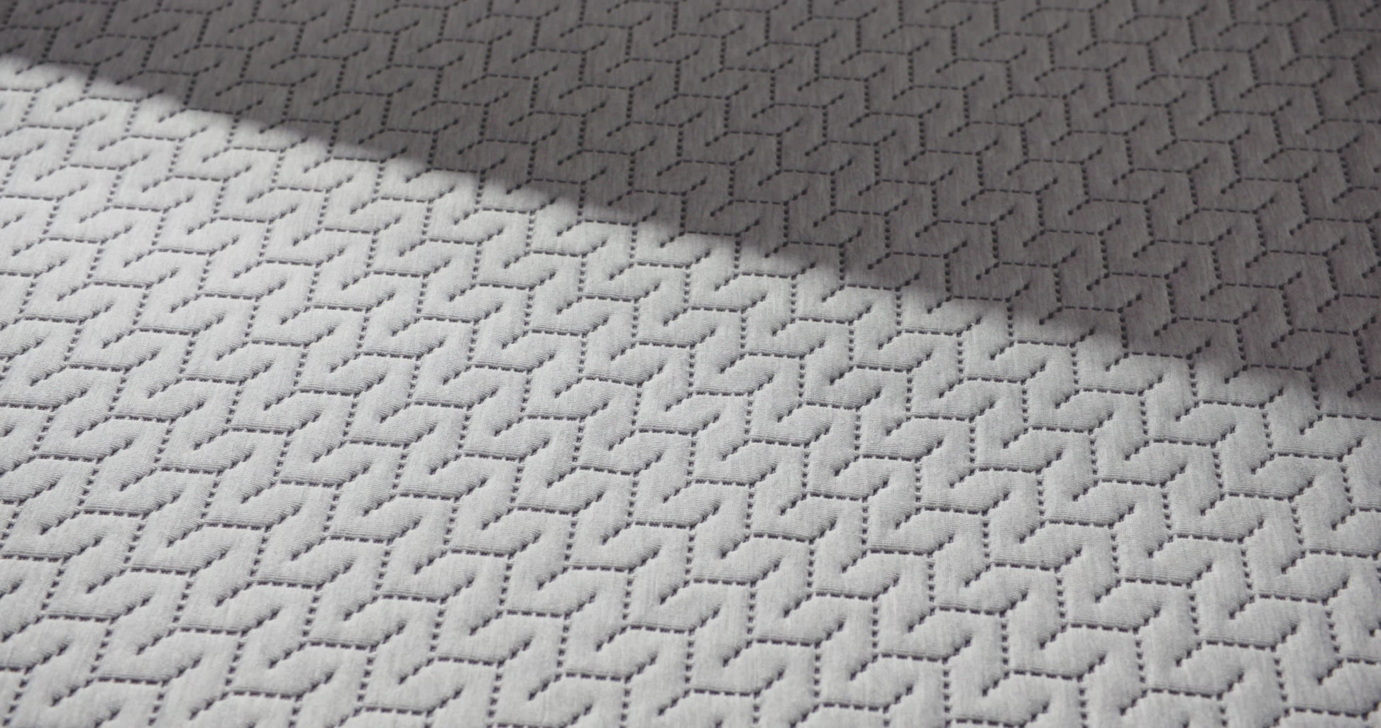 close up of a hand pressing into the top of the 12 inch foam mattress