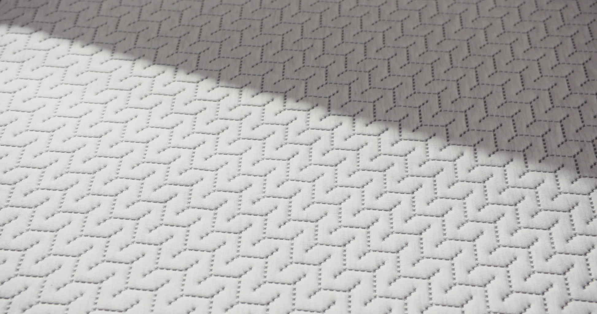 Person presses hand on a foam mattress.