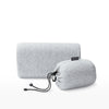 The Tuft and Needle Anywhere Travel pillow next to the carrying sack ||color:granite