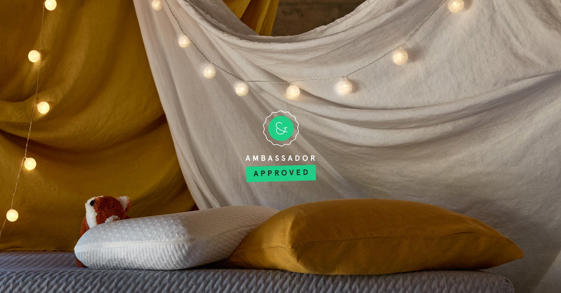 Blanket fort with string lights built over a Tuft & Needle mattress and foam pillow