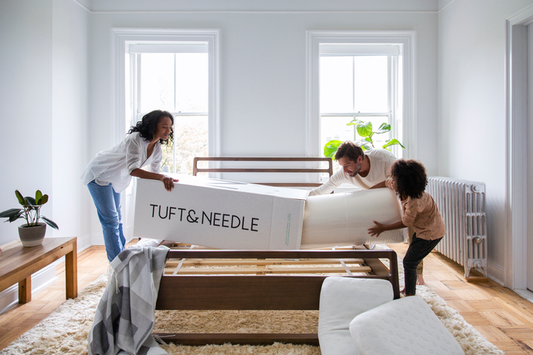 Picture of a family pulling out their T&N Mattress of the box in came in
