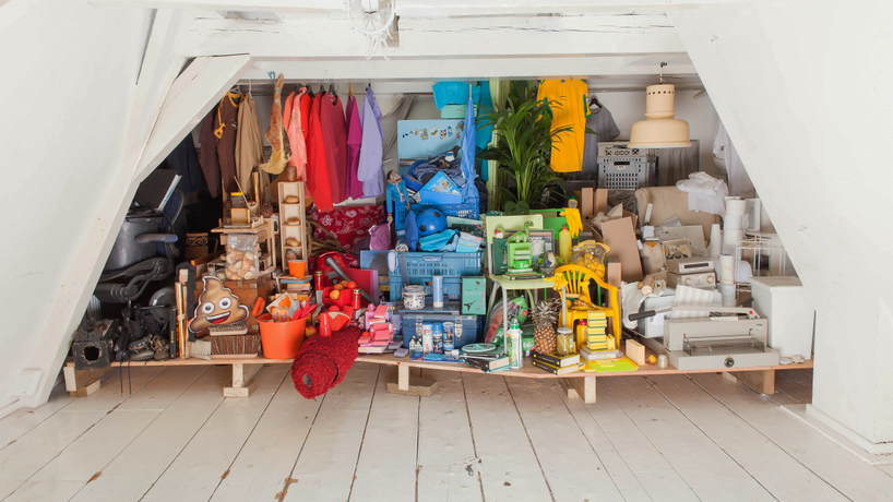 A bunch of knick knacks in a closet sorted by color making the closet look like a rainbow