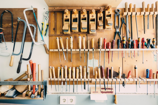 A wall of tools hanging in a garage