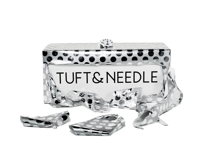 Tuft & Needle Mattress Box Wrapped in silver & black polka dotted wrapping paper with a bow on top