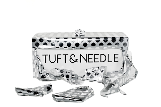 Tuft & Needle Mattress Box Wrapped in silver & black polka dotted wrapping paper with a bow on top