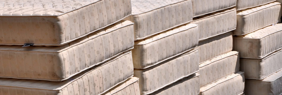 A very large pile of old mattresses waiting to be recycled