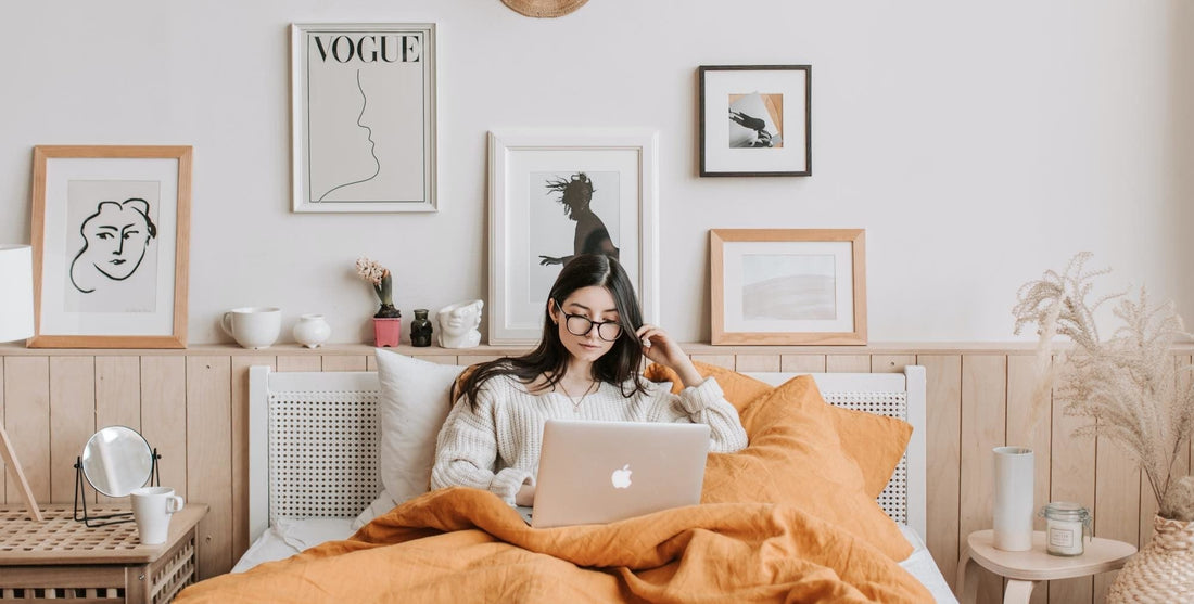 Woman working from a laptop from the comfort of her bed