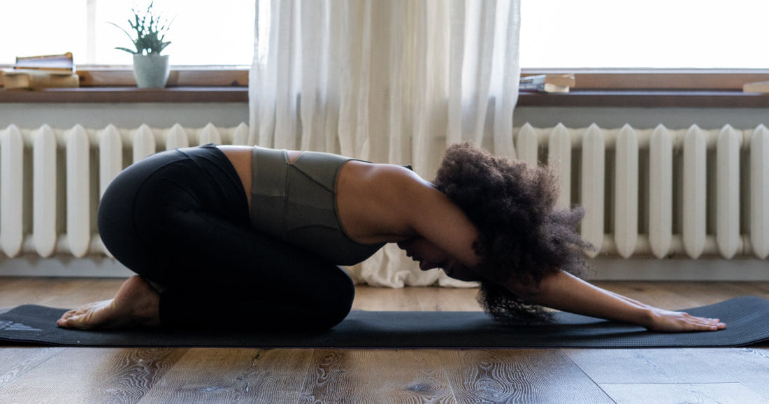 Lady doing a yoga pose on a yoga mat