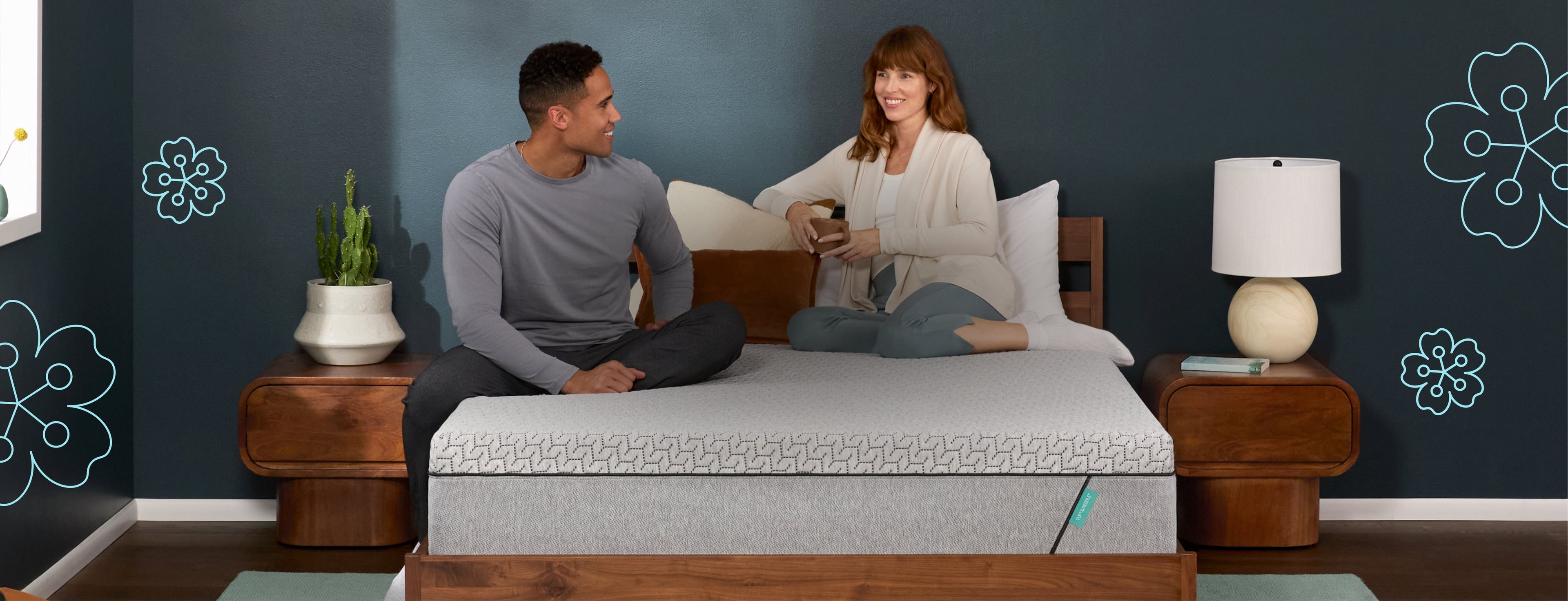 Man laying on the left and woman sitting on the right of a Tuft and Needle Original Hybrid mattress