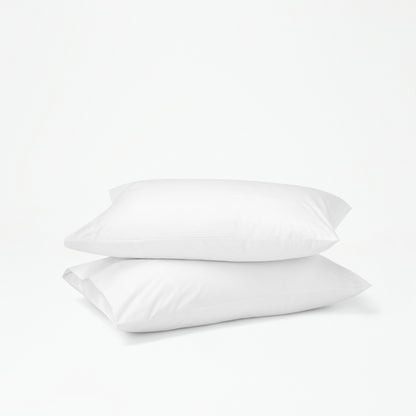 The Tuft and Needle Percale Pillowcase Set on two stacked pillows||color:cloud