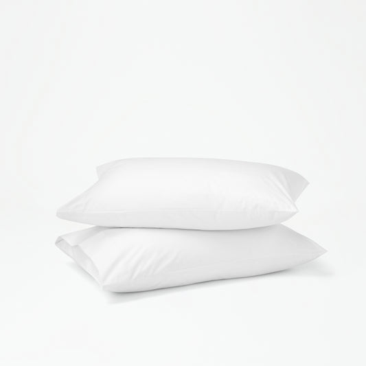 The Tuft and Needle Percale Pillowcase Set on two stacked pillows||color:cloud