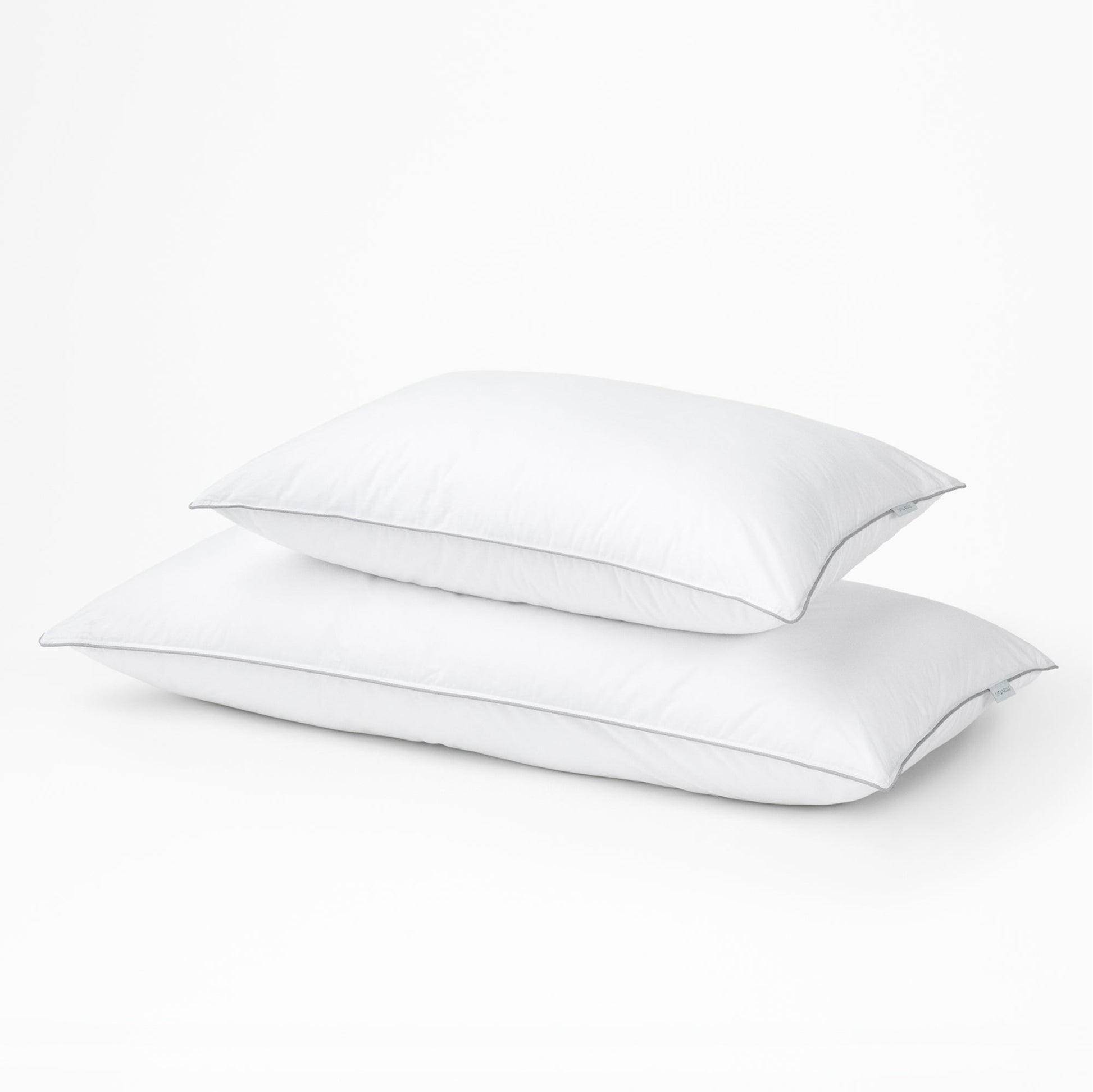 Two tuft and needle down alternative pillows, standard on top and large on the bottom