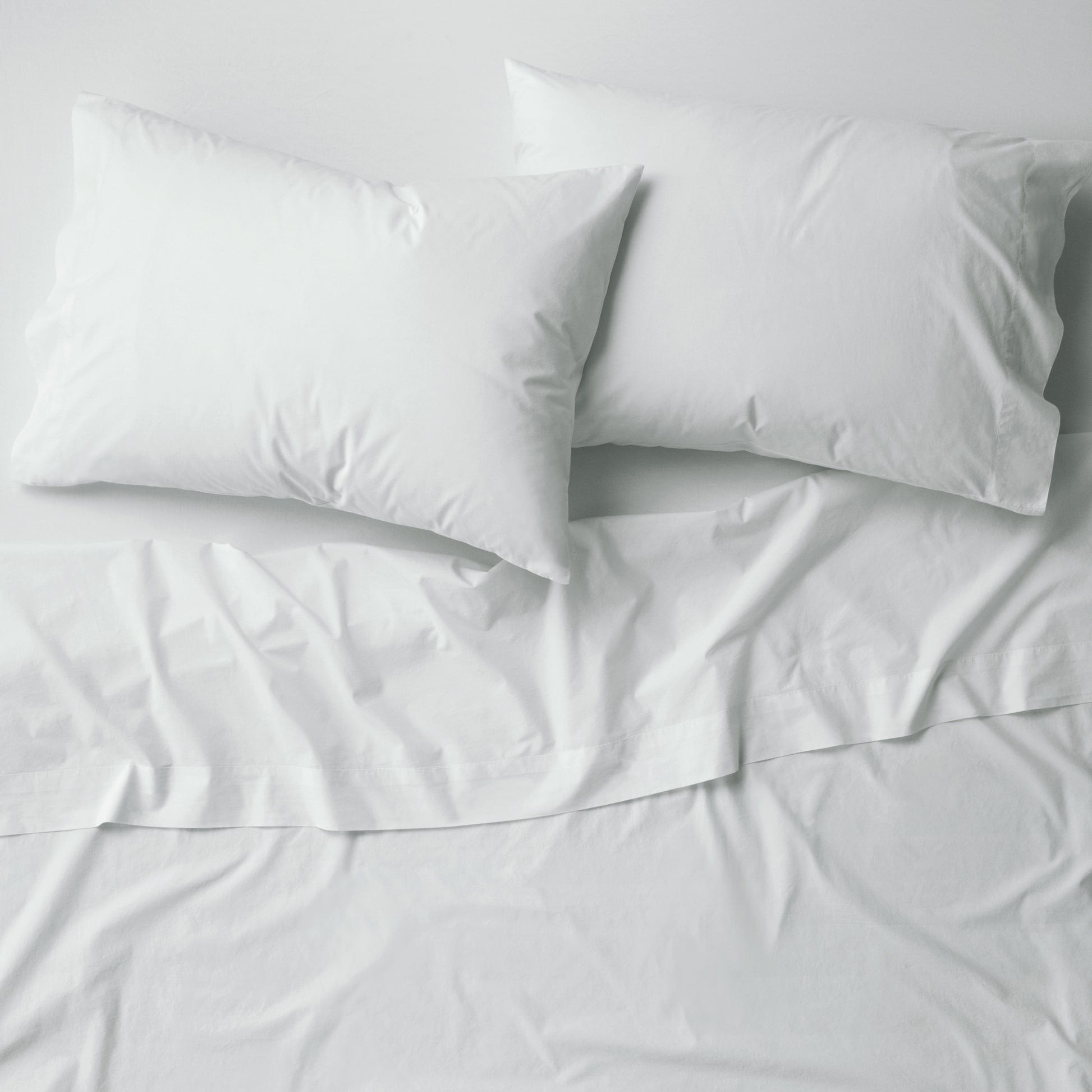 The Tuft and Needle Percale Pillowcase Set on a mattress||color:glacier
